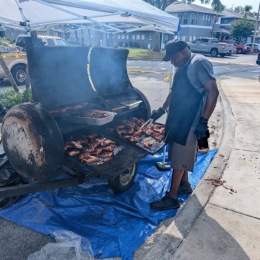 man around BBQ pit