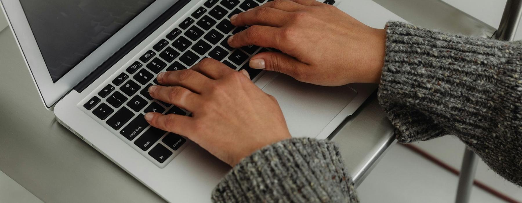 A person typing on a laptop.